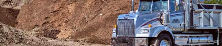 A truck drives by a mound of earth.