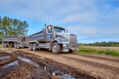 A truck drives across a muddy road.