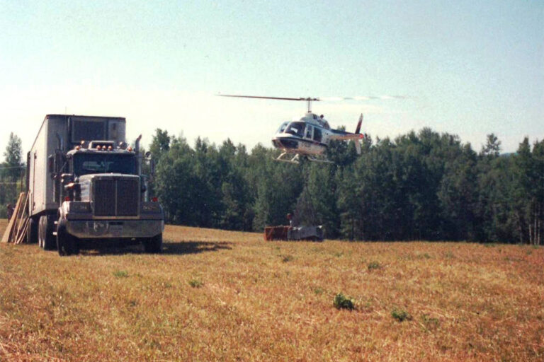 An old photo of a truck and helicopter.