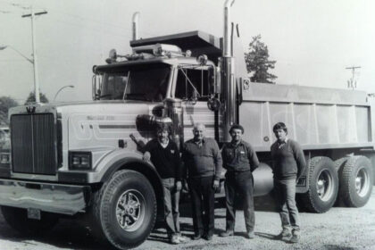 A black-and-white photo depicts Michell team members posing in front of a truck.