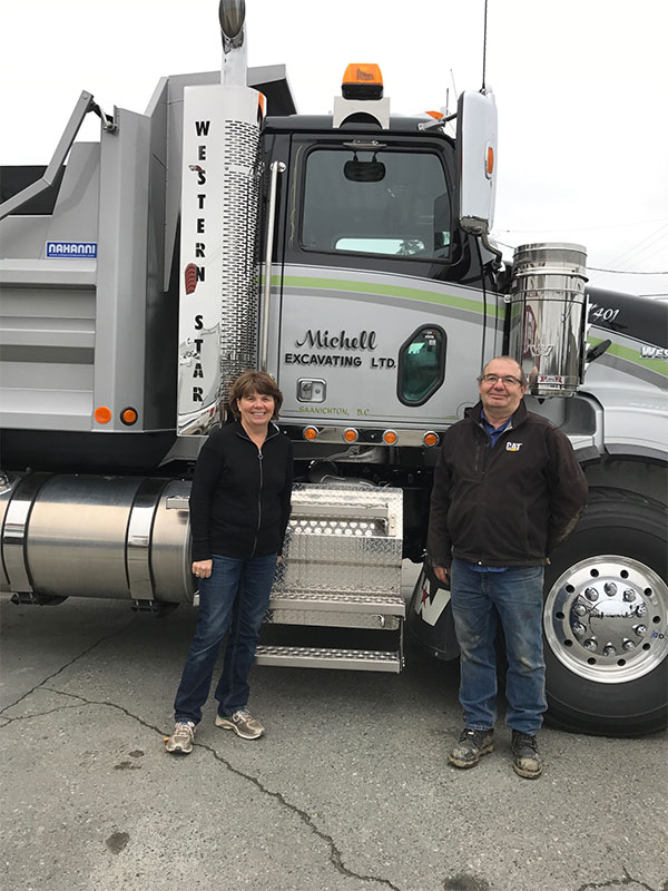 Two Michell team members pose in front of their truck.